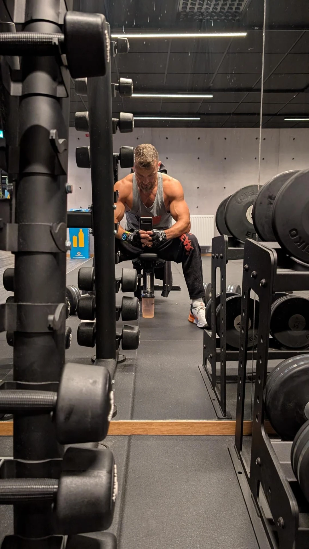 Athlete pushing a weighted sled in a dark arena